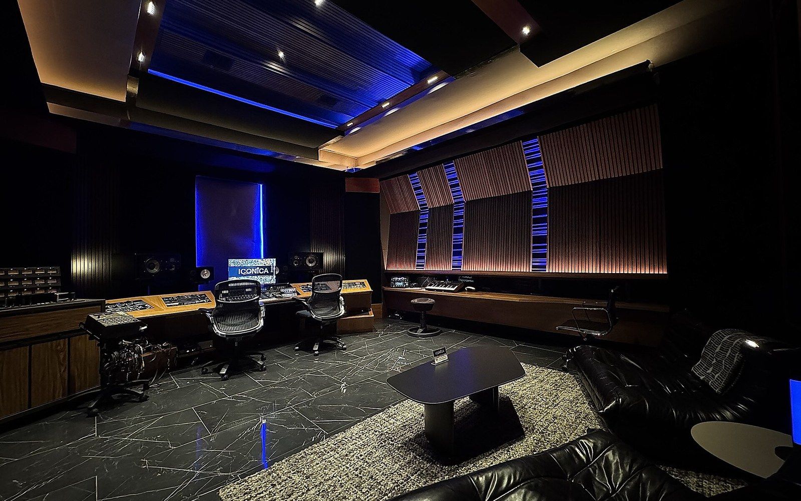 A control room window looking into an empty live room